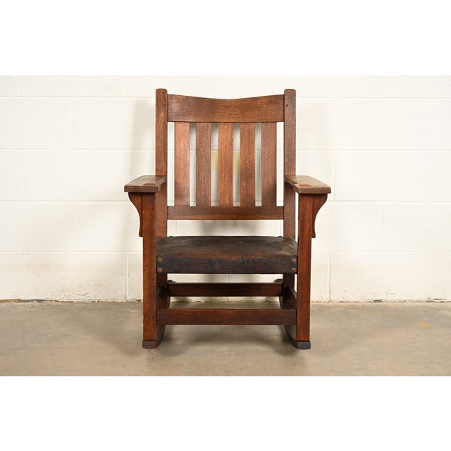 A gorgeous antique Mission or Arts & Crafts period V-back rocking chair By Gustav Stickley USA, Circa 1910 Solid quarter...