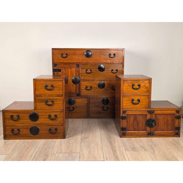 A Japanese tansu; includes a central tansu flanked by two step-shaped or tiered small tansu units, can be referred to as...