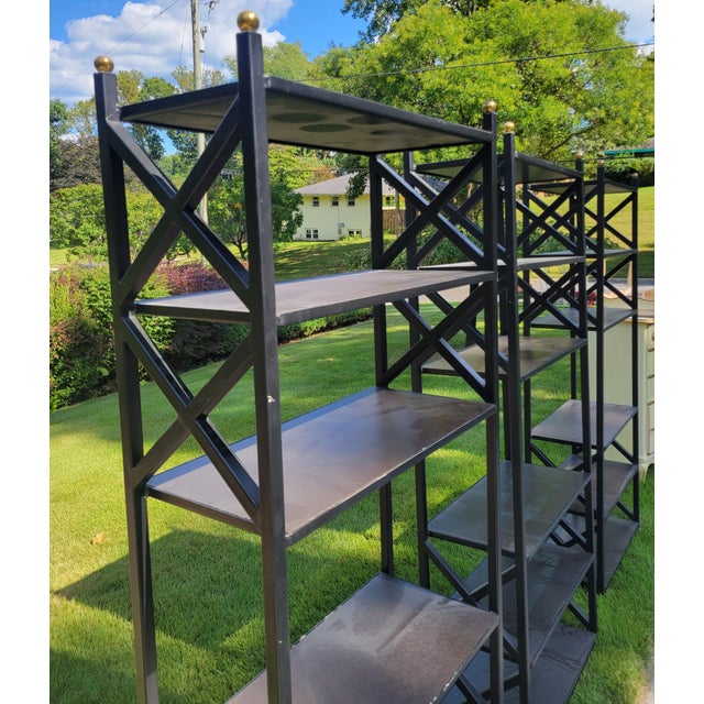 Black steel etagere with wood inserts, brass sphere finials, and X forms on both sides. Constructed with a single welded...