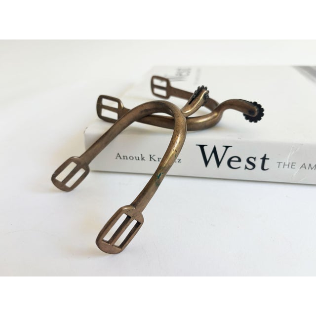 Kick up the equestrian vibes in your décor with this pair of antique brass horse riding spurs, possible attribution to...