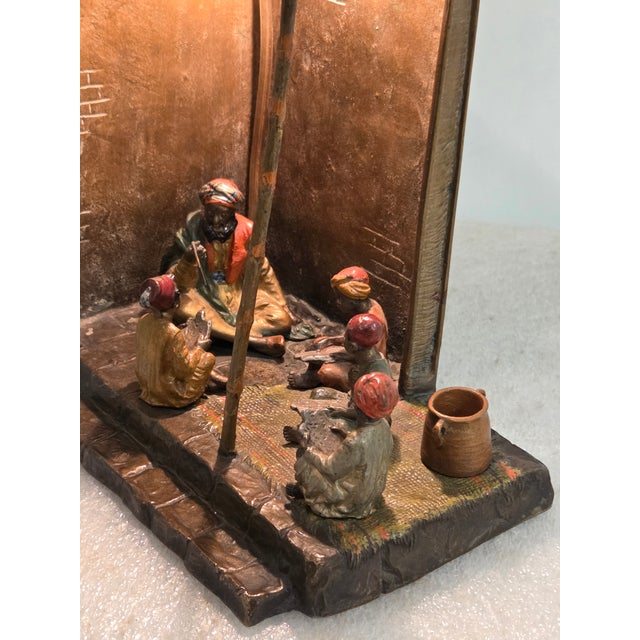An exquisite early 20th-century Vienna bronze lamp depicting an Arab school teacher and four young students wearing...