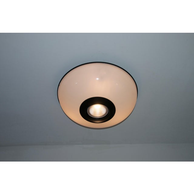 Model combi a305 ceiling lamp by arteluce, 1970s. This striking vintage light features a bold circular form with a large...