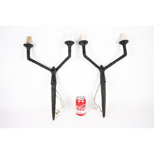 A vintage pair of sculptural and patinated Giacometti style dark bronze wall sconces with a naturalistic branch or twig...