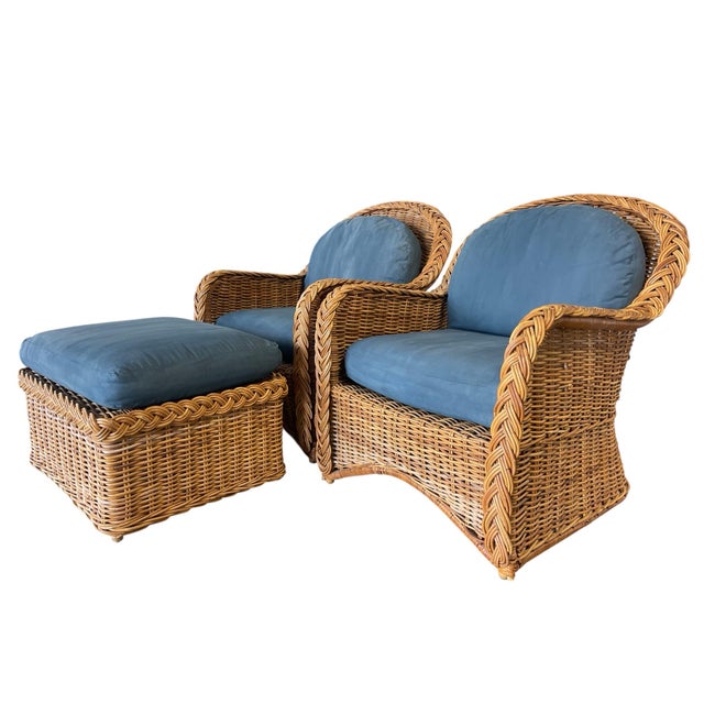 A substantial pair of vintage organic modern rattan lounge chairs with matching ottoman, distinguished by bold braided arm...