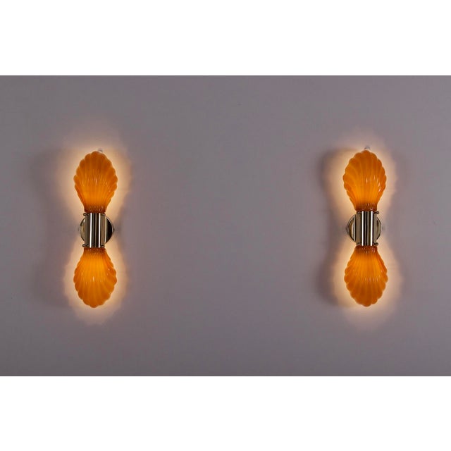 Pair of double shell sconces in amber pressed glass, lined on the inside with a thick layer of white opaline. Both glass...
