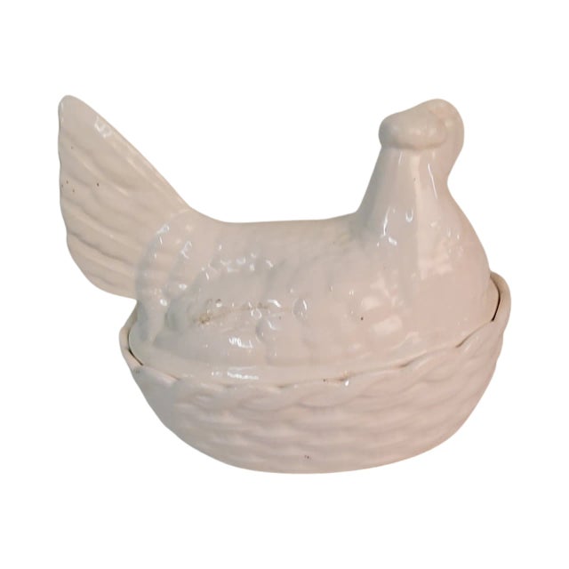 A white ceramic hen on nest measures 8" wide by 6" high