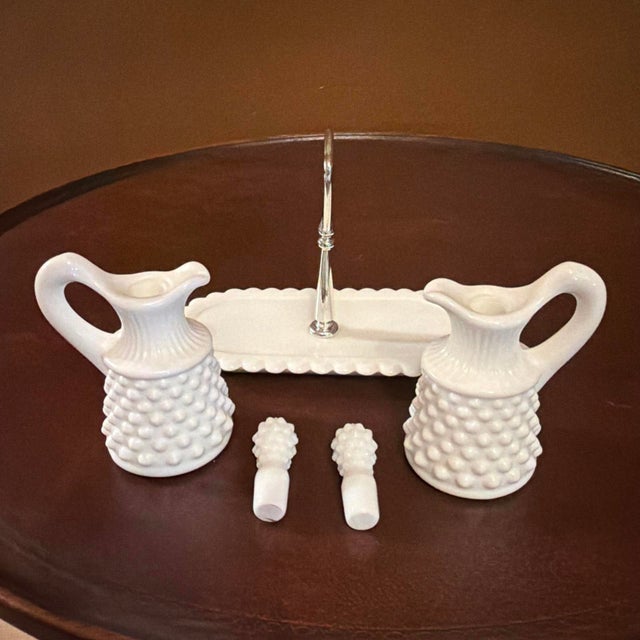 This Vintage Fenton Hobnail Milk Glass Oil Vinegar Cruet Set features a classic English Hobnail pattern on round, white...