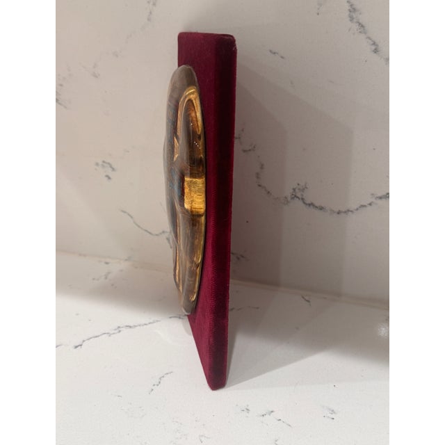 A striking vintage Murano glass crucifix in the San Damiano style, beautifully mounted on a rich burgundy velvet-covered...