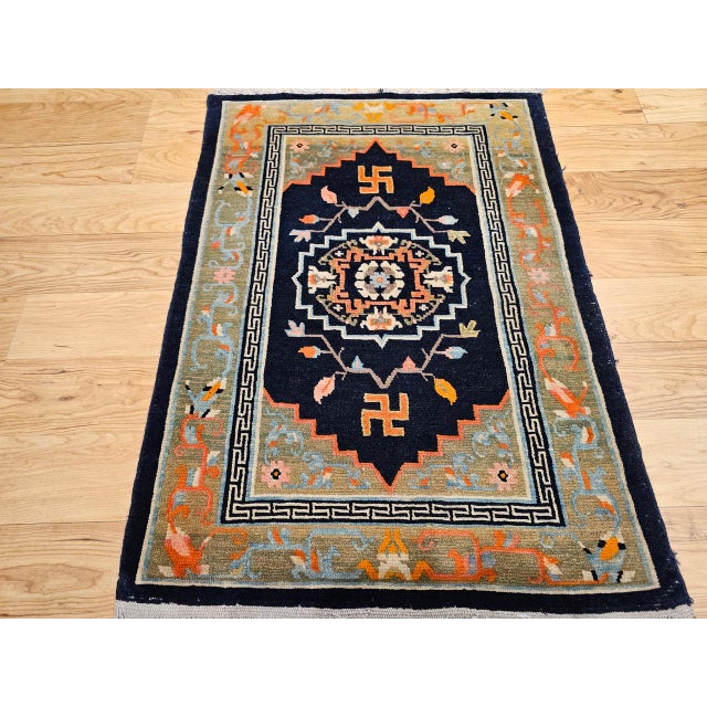 This vintage Tibetan rug is a striking and meaningful piece, featuring a bold medallion design set against a deep black...