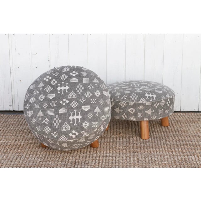 This versatile pair of round dhurrie ottomans, features a stunning cotton cover adorned with an African mudcloth style...