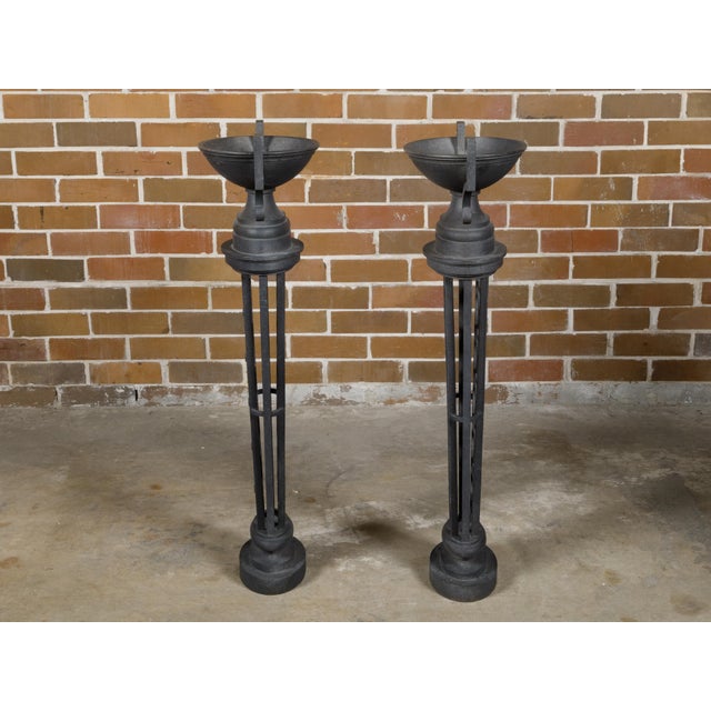 A pair of English Victorian period cast iron planters from the 19th century with Neoclassical urns sitting atop tapering...