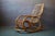 Made entirely of natural rattan, this 1970s rocking chair charms with its light and airy silhouette. The faux leather...