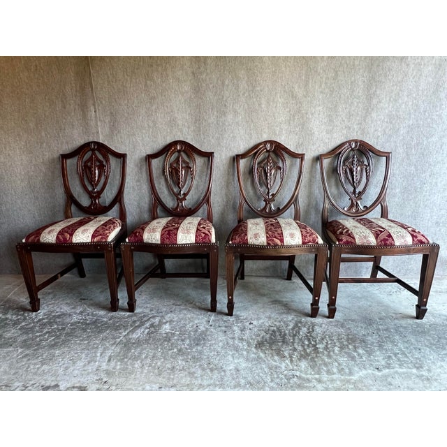 Set of 8 beautifully carved mahogany Hepplewhite style chairs in need of restoration. This set includes two arm chairs and...