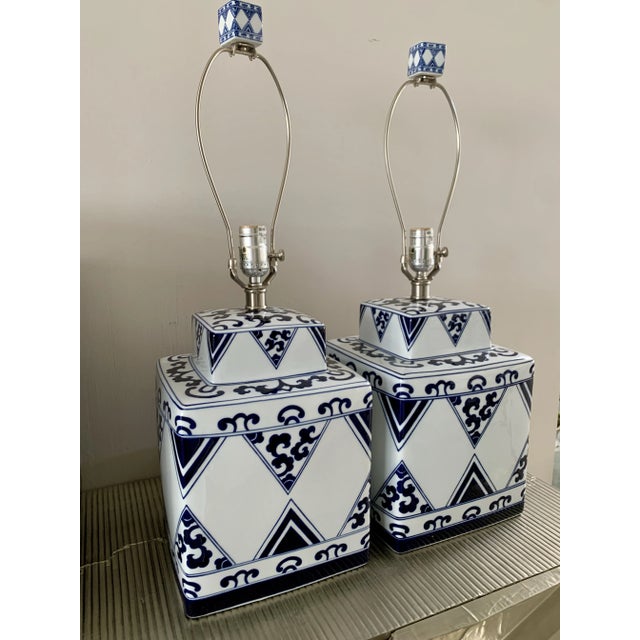 Chinoiserie porcelain table lamps in a blue and white pattern. These large, square lamps still have their original,...