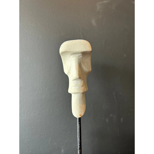 Striking, stylized carved head in white stone mounted to a wood block on an iron pole by Jose Luis Martinez Gomez (signed).