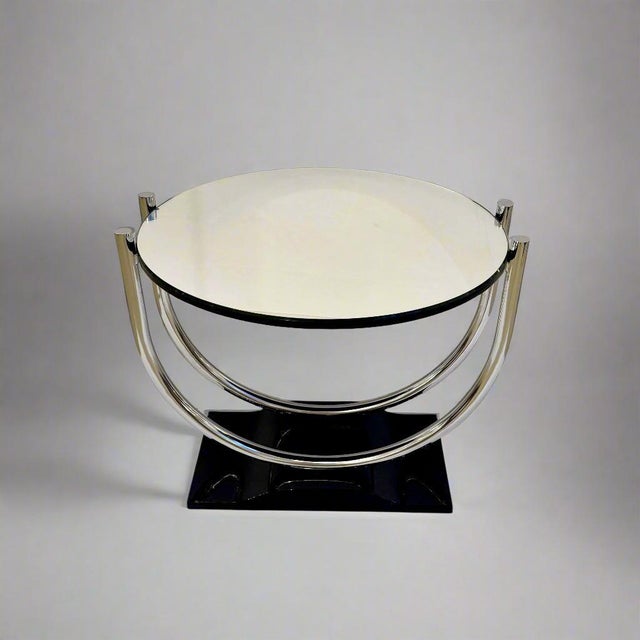 A French Art Deco period round side table from France circa 1930. The Black lacquer base supports a double U shaped...