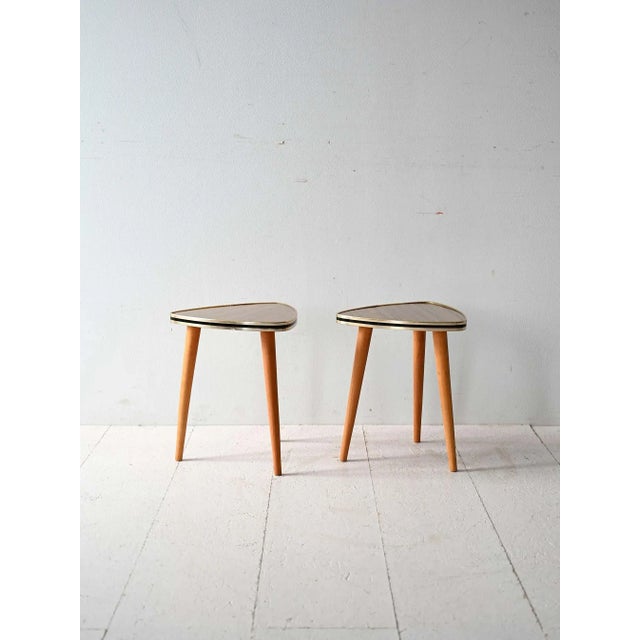 Pair of vintage Scandinavian coffee tables from the 1970s in Formica and oak with a triangular design and soft lines. This...