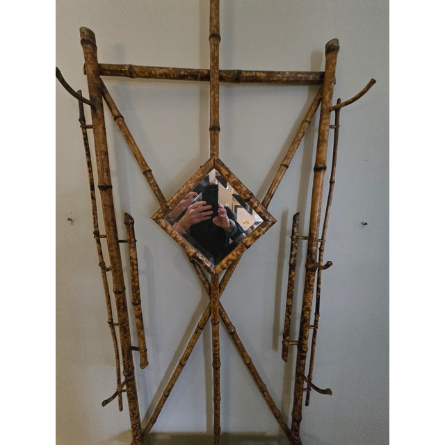 This is an antique English bamboo Hall Tree form the late 19th century. This has a diamond shaped beveled mirror and four...