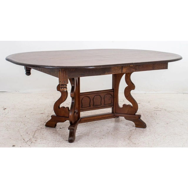 Spanish Renaissance Revival Extending Oak Oval Dining Table, raised on carved pedestal base, with two leaves. Without...