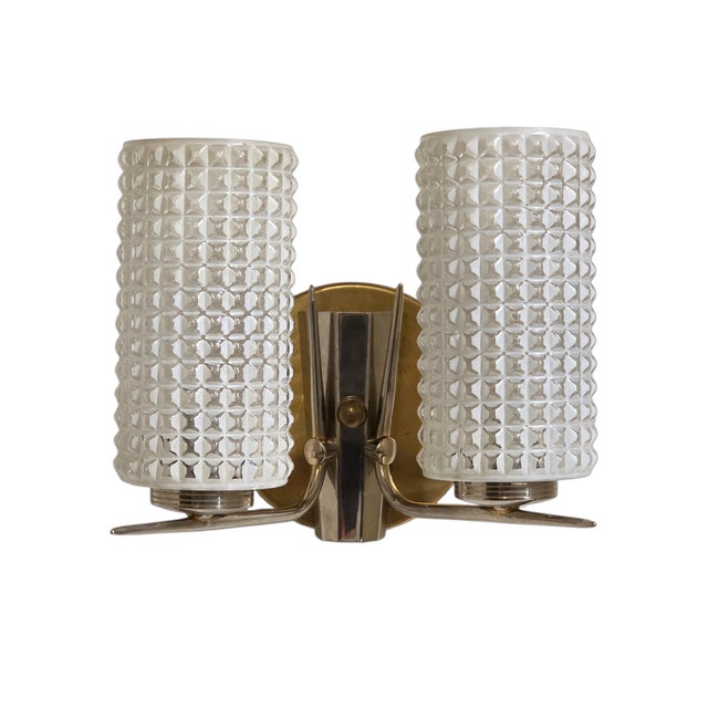 A striking Mid-Century Modern double-light vintage wall sconce, featuring two tall textured and molded glass cylindrical...