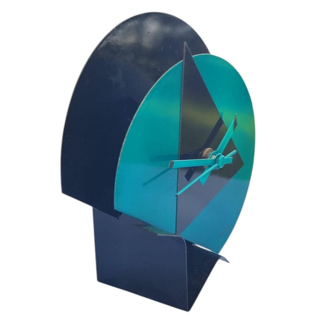 Table clock produced in the early 1980s, postmodern, made of lacquered metal, with green and black dial on a black...