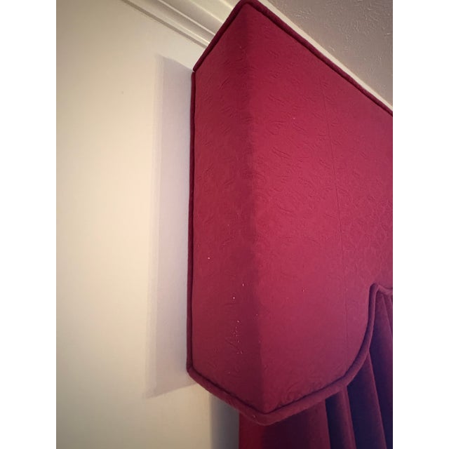 This window treatment set includes a custom upholstered cornice valance paired with full-length pleated drapery panels in...