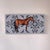 This artwork features a detailed portrayal of a chestnut horse set against a softly patterned background that enhances its...