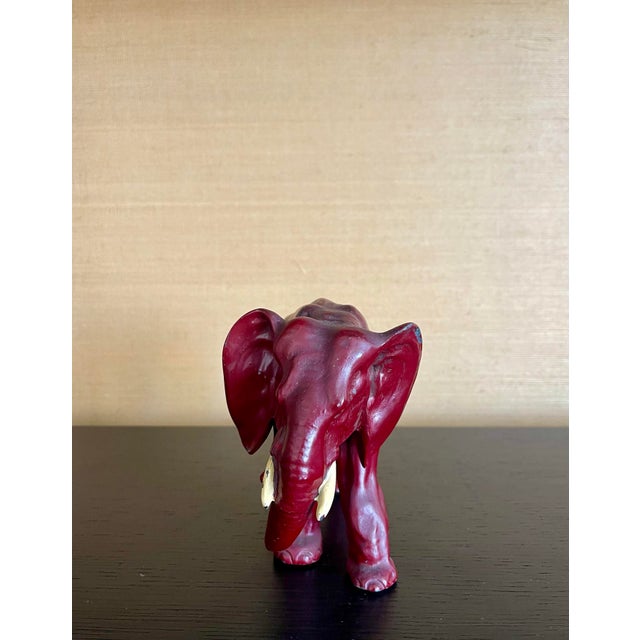 A sculptural mid-century elephant cast in solid metal and finished in a rich oxblood red lacquer. With its elegant...