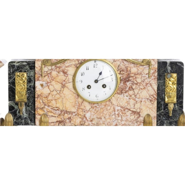 Clocks - Art Deco Garniture. French; circa 1940. Composed of a pair of candlesticks and a table clock in two-tone marble;...