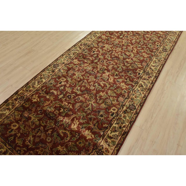 A traditional Agra runner hand-knotted with an all-wool pile on a cotton foundation. This finely woven oriental rug...