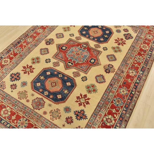 A tribal Caucasian Kazak rug hand-knotted with fine wool on a cotton foundation. This rug features geometric medallions...