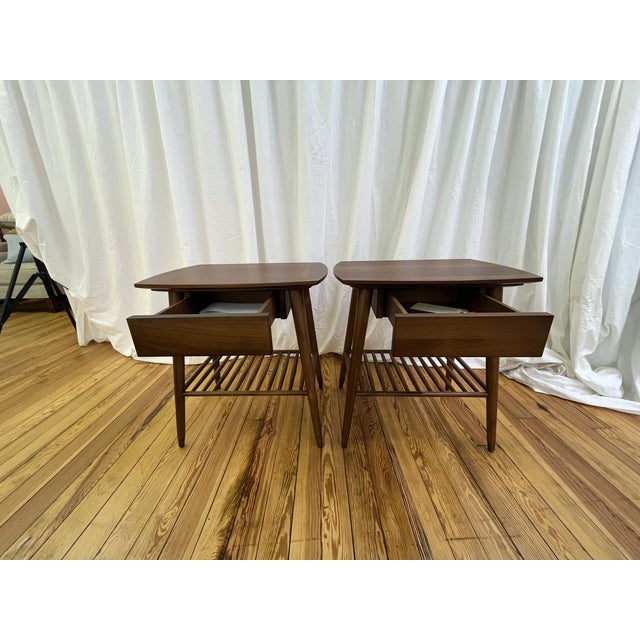 This exceptional pair of mid-century modern style end tables is a masterclass in clean architectural lines and functional...
