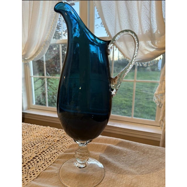 The Vintage Empoli Italian Murano Blue Art Glass Pitcher is a stunning piece of glassware that combines traditional...