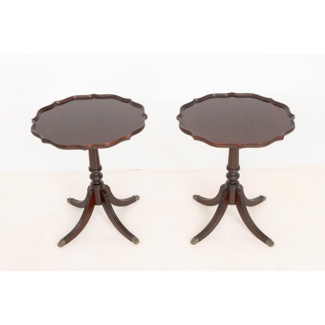 Pair of Regency Style Mahogany Pie Crust Edge Side Tables, each on turned pedestal support and four fluted feet with brass...