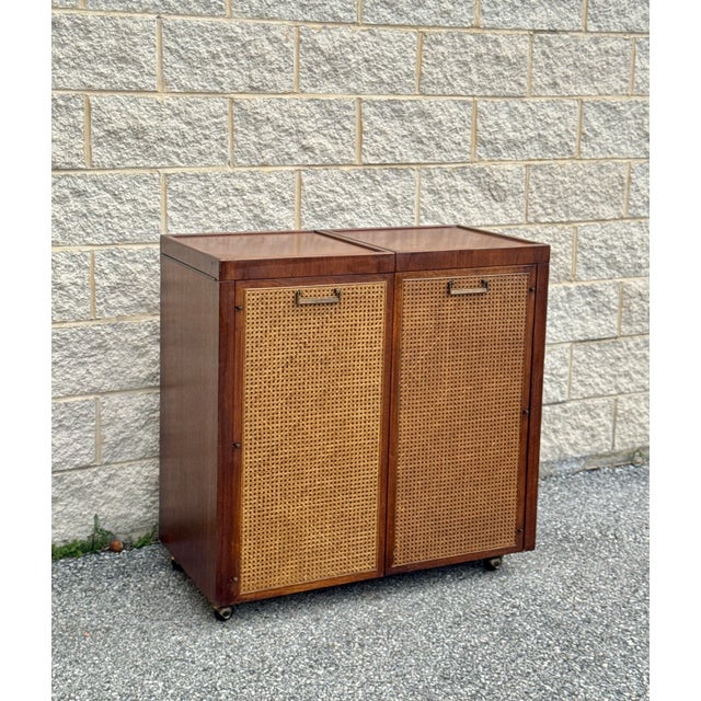 Mid-century walnut bar cabinet with a compact case and sliding top extension. Rectilinear form with two front doors inset...
