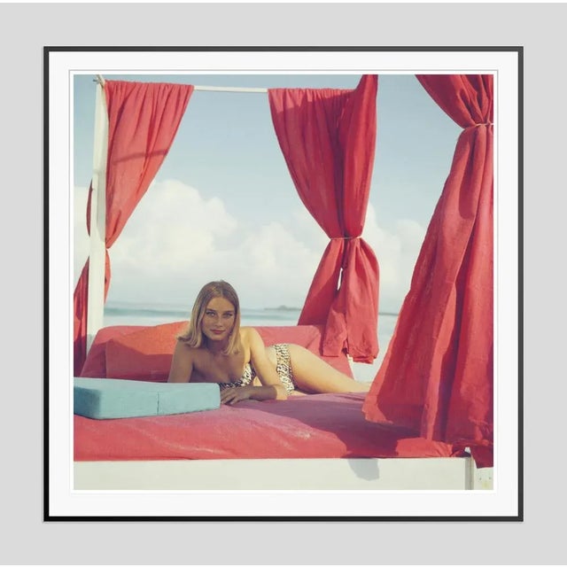 Tania Mallet' by Slim Aarons Open Edition 1961: Actress Tania Mallet relaxes on a red-curtained four poster in Eleuthera,...