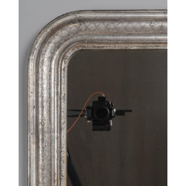 A French Louis Philippe style mirror with curved top corners, incised decoration and silver leaf finish. Original mirror...