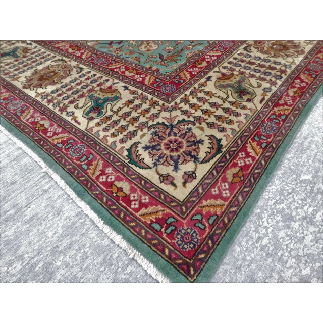 Classic Shah Abbas floral style on green background, within ivory border.