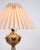 Table lamp made in brass with a white lampshade from the 1930s. The lamp features a simple design with a round base and...