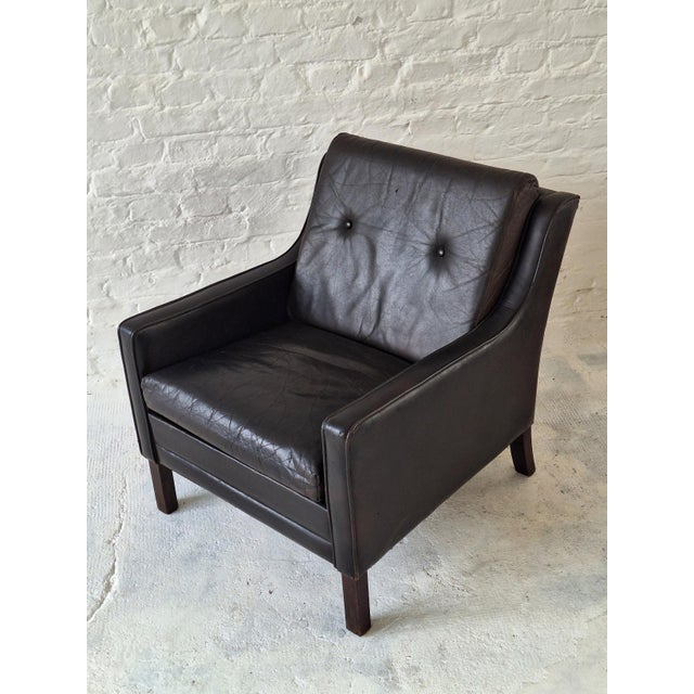Finely made Danish lounge chair in dark brown leather dating from the 1960s. Buttoned back, fine stitching.