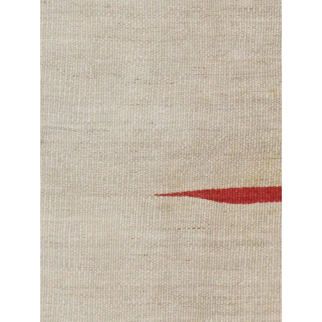 A vintage Persian Kilim flat-woven rug from the mid-20th century.