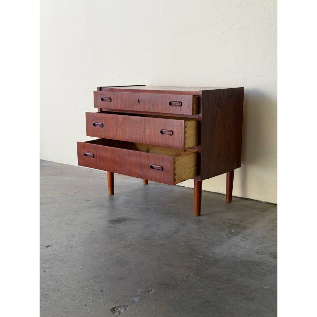 Charming Mid Century Modern Danish chest crafted in warm teak, featuring clean Scandinavian lines and elevated tapered...