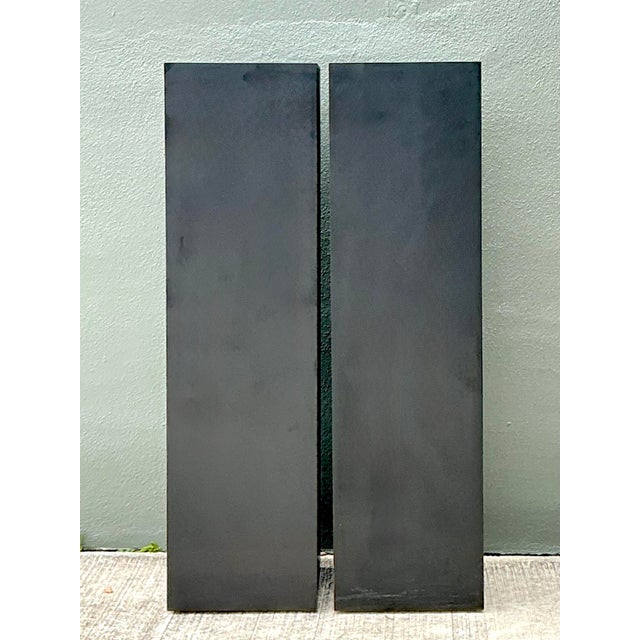 This striking pair of statuesque pedestals embodies the sleek, architectural minimalism of the late 20th-century Post-...