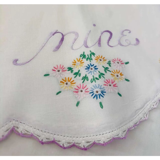 A tender and deeply personal pair of mid-century heirloom pillowcases, beautifully hand embroidered with the words "Mine"...