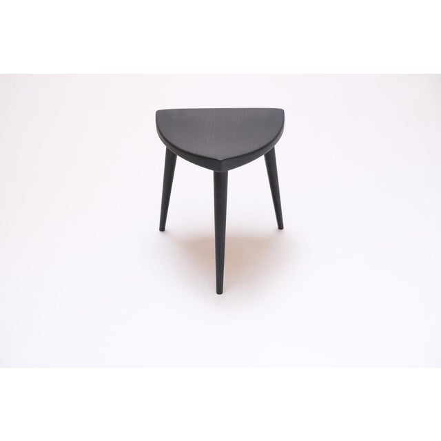 Inspired by George Nakashima's "Mira" stool, this curved black oak top incorporates through body tenons with wedge...