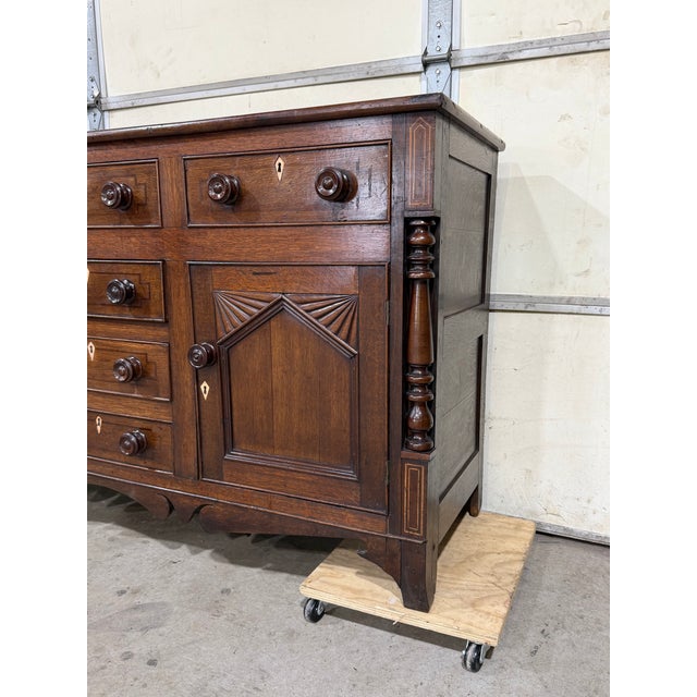 This is an early 19th-century English dresser base with timeless charm. The piece features six drawers, flanked by doors...