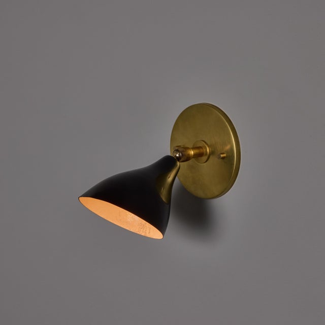 1960s Gino Sarfatti Model #26b Black and Brass Wall Lamp for Arteluce Executed in black aluminum with a brass backplate....