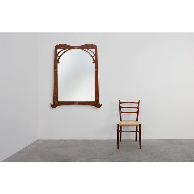 A graceful Art Nouveau wall mirror crafted in oak with gilded inlay, France, circa 1915. The frame’s flowing silhouette...