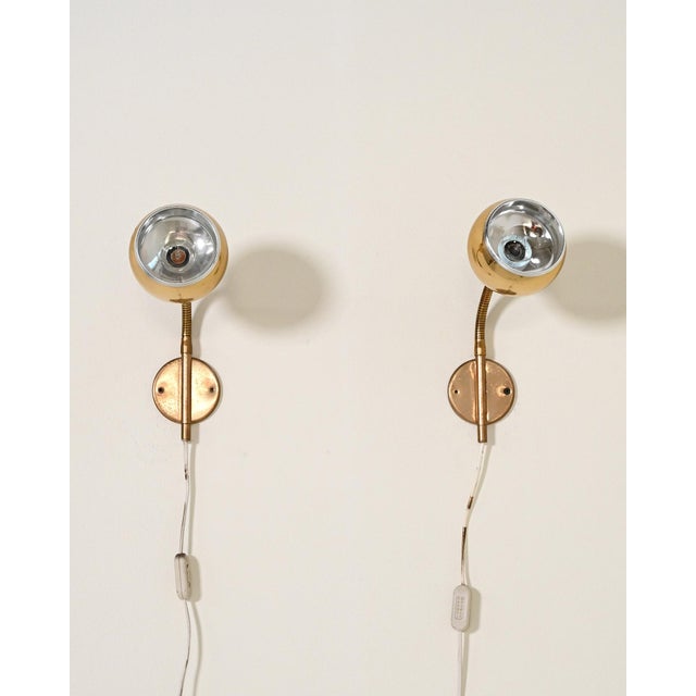 Pair of brass wall lamps with adjustable diffusers and flexible arms. Mae 77 and semko markings present. Möllers armatur...
