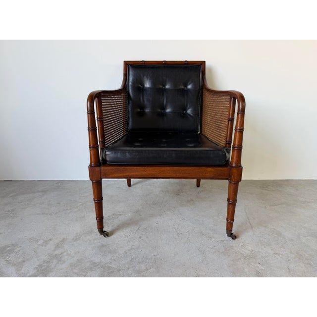 Elegant 1970s Regency-style lounge armchair by Hickory Chair, featuring a faux bamboo mahogany frame accented with finely...